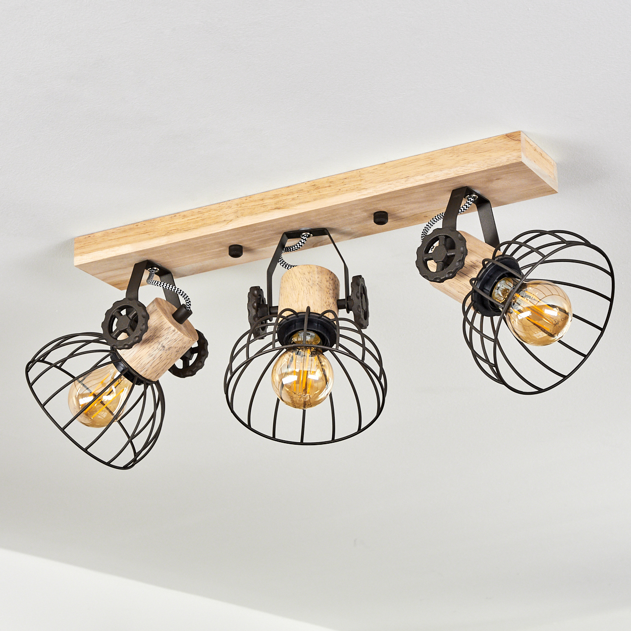 Deckenleuchte mit Holzsockel und drei schwarzen Drahtkäfig-Lampenschirmen.