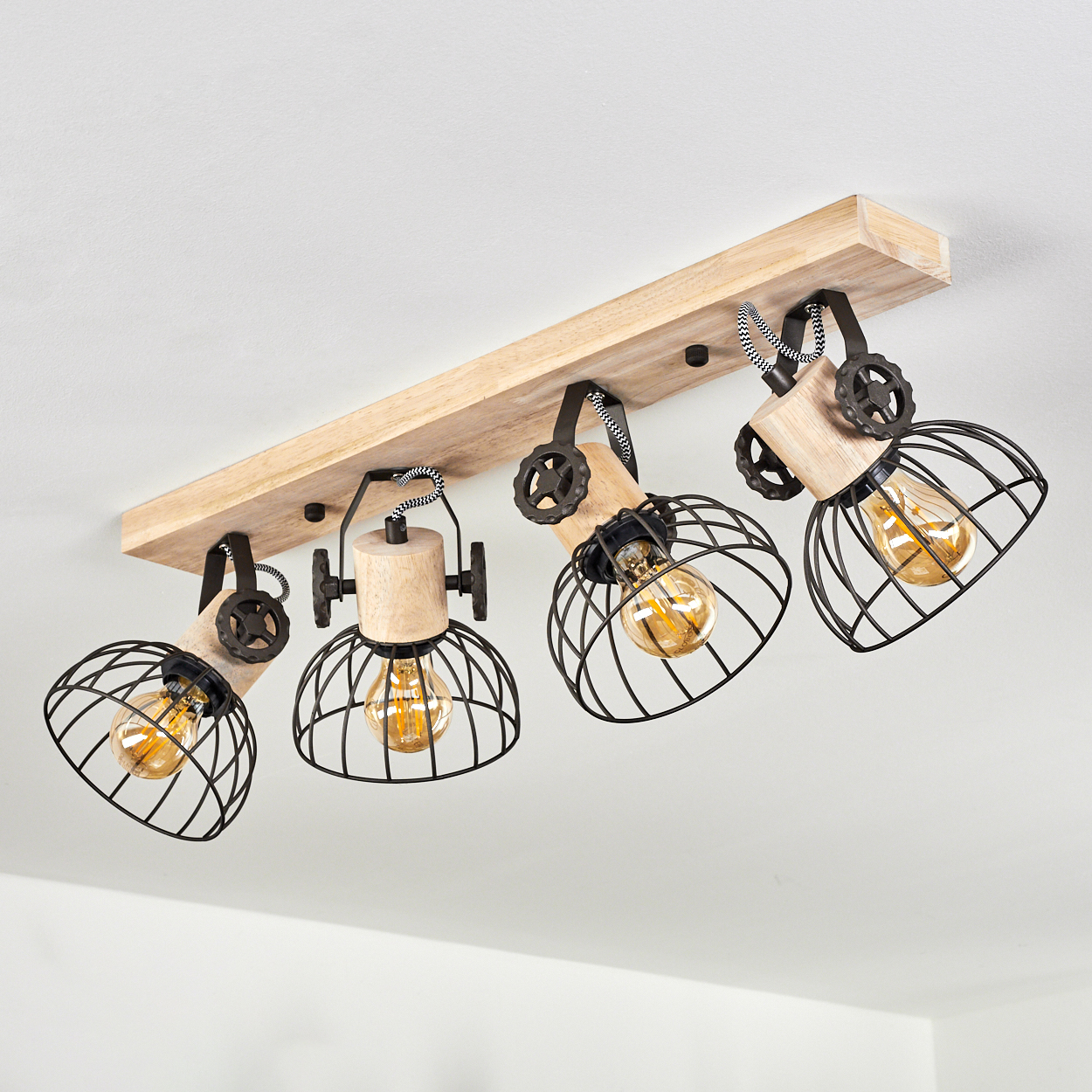 Holzsockel mit vier schwarzen Drahtkorb-Lampen und sichtbaren Glühbirnen.
