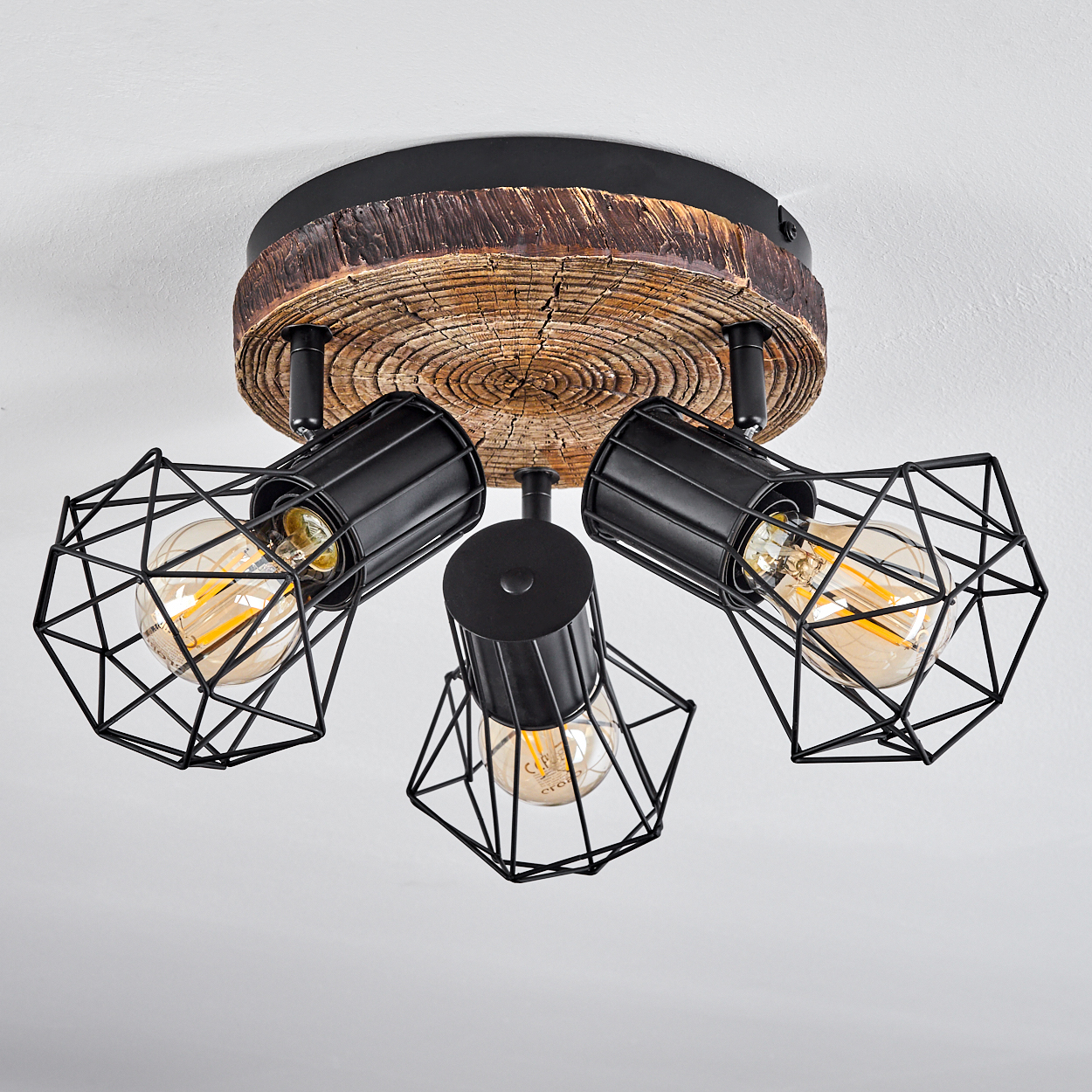 Deckenleuchte mit Holzscheiben-Optik und drei schwarzen Metallkäfig-Lampenschirmen.