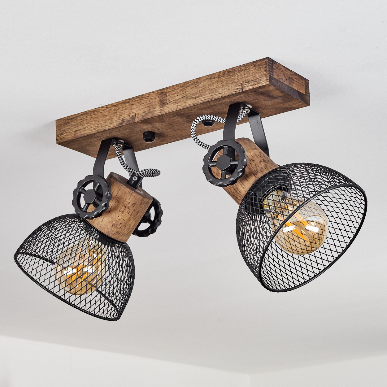 Deckenleuchte mit Holzsockel, zwei verstellbaren Lampen mit schwarzem Drahtgeflecht und Glühbirnen.