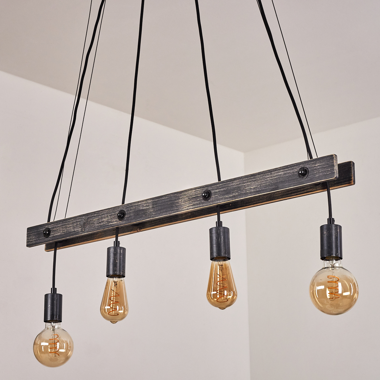 Eine Holzbalken-Pendelleuchte mit vier Edison-Glühbirnen, schwarz.