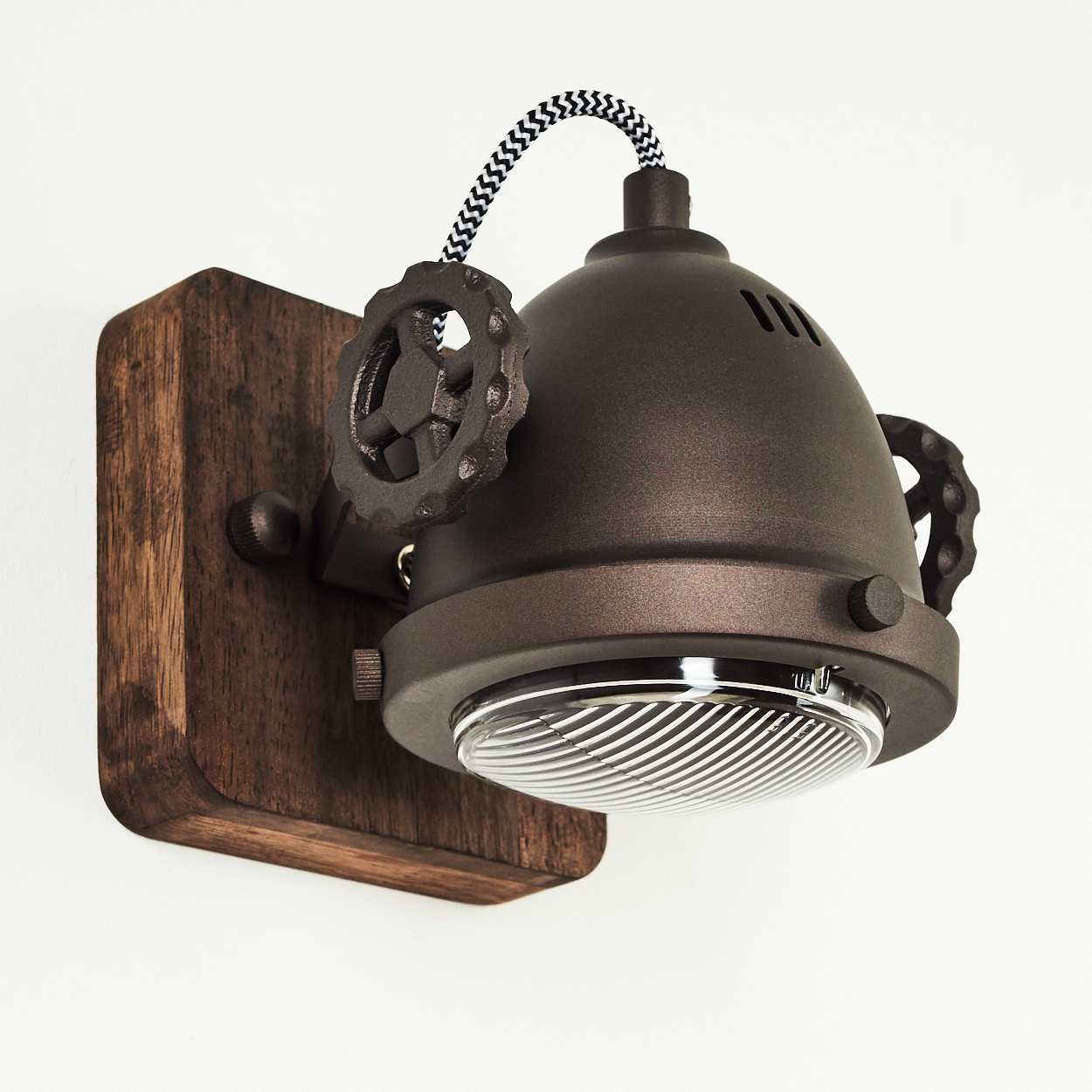 Eine braune Wandleuchte im Industriestil mit Holzsockel und Zahnrad-Details.