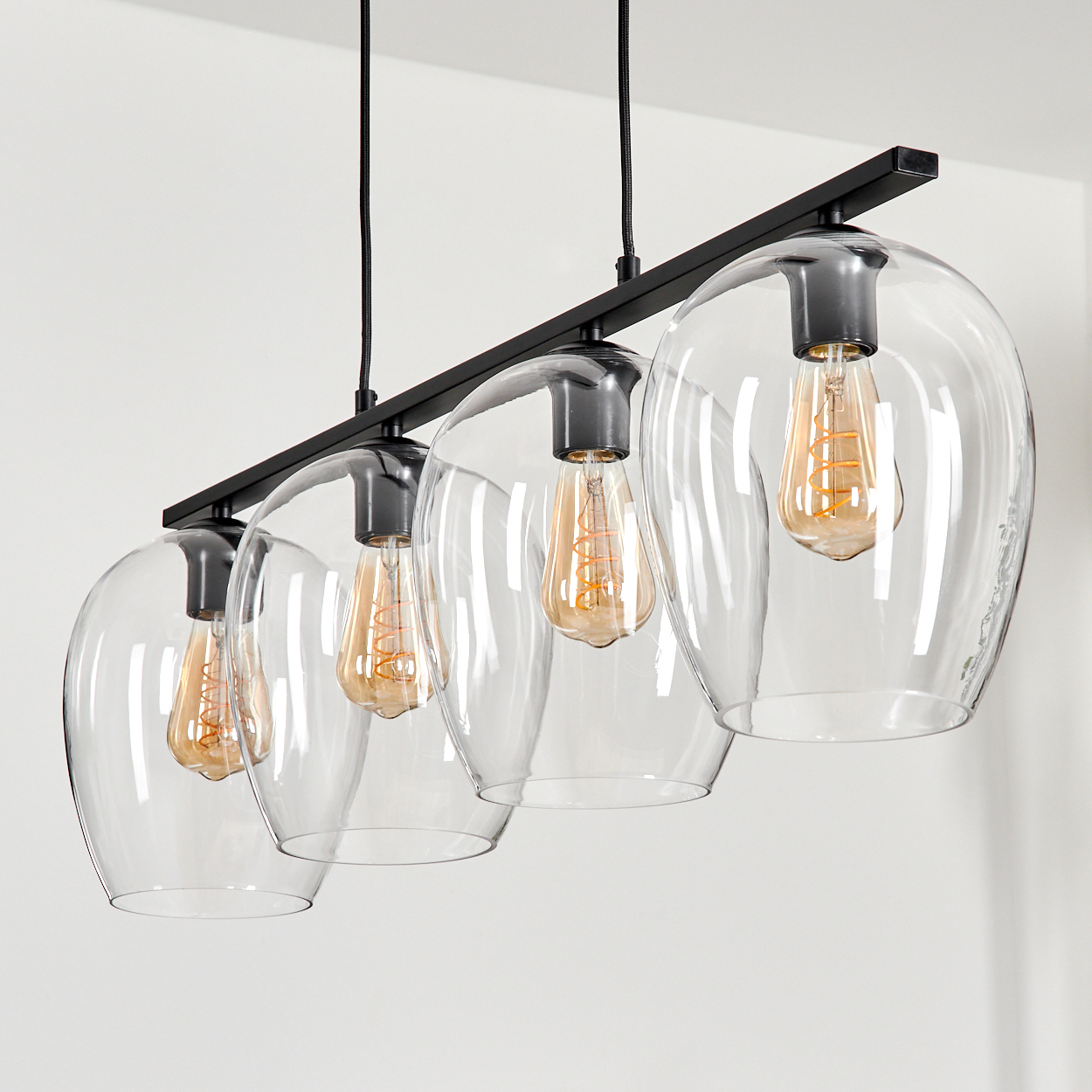Schwarzer linearer Kronleuchter mit vier Klarsichtgläsern und Edison-Glühbirnen.