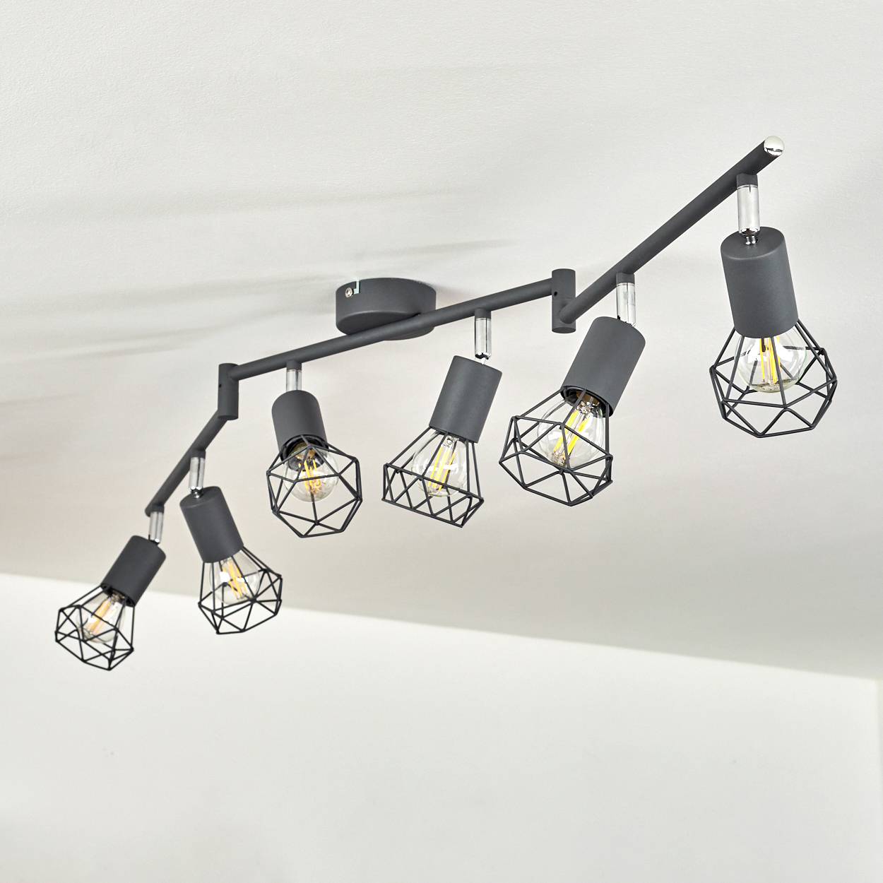 Schwarzer Deckenstrahler mit sechs Lampen und geometrischen Gitterschirmen.