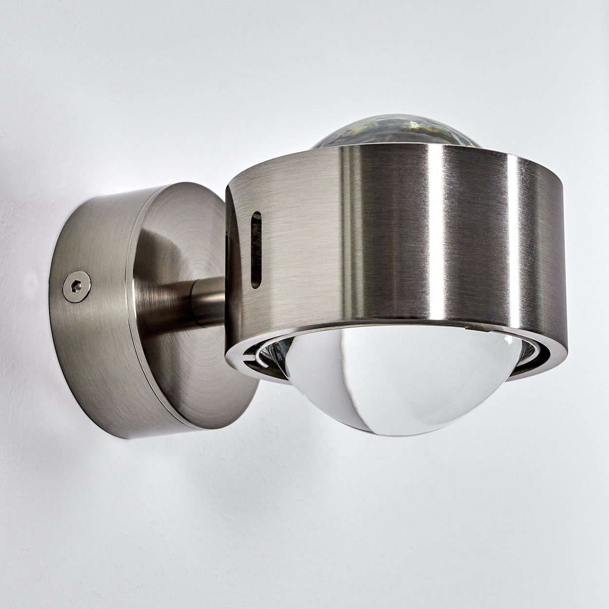 Eine moderne Wandleuchte aus gebürstetem Metall mit Glaskuppeln.