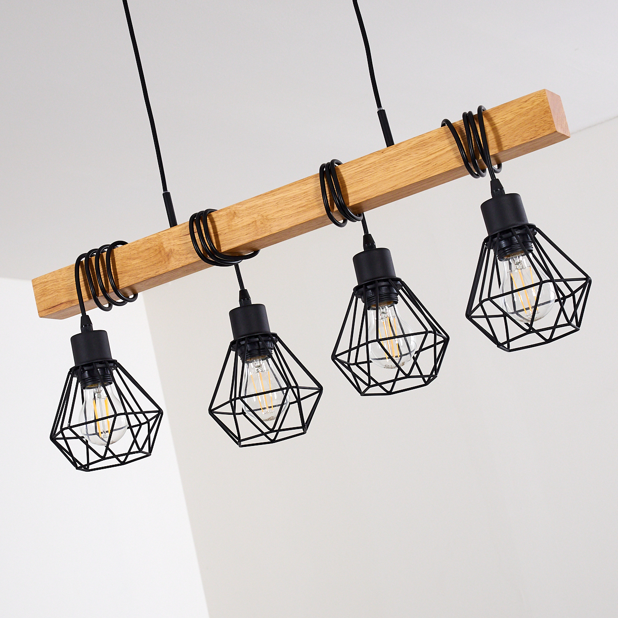 Holzbalken mit vier schwarzen Diamantkäfig-Pendelleuchten, jede mit Edison-Birne.