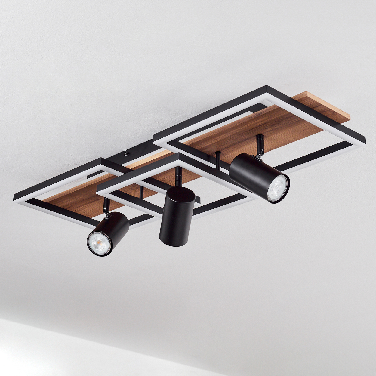 Moderne Deckenleuchte mit Holz und schwarzen Zylindern.