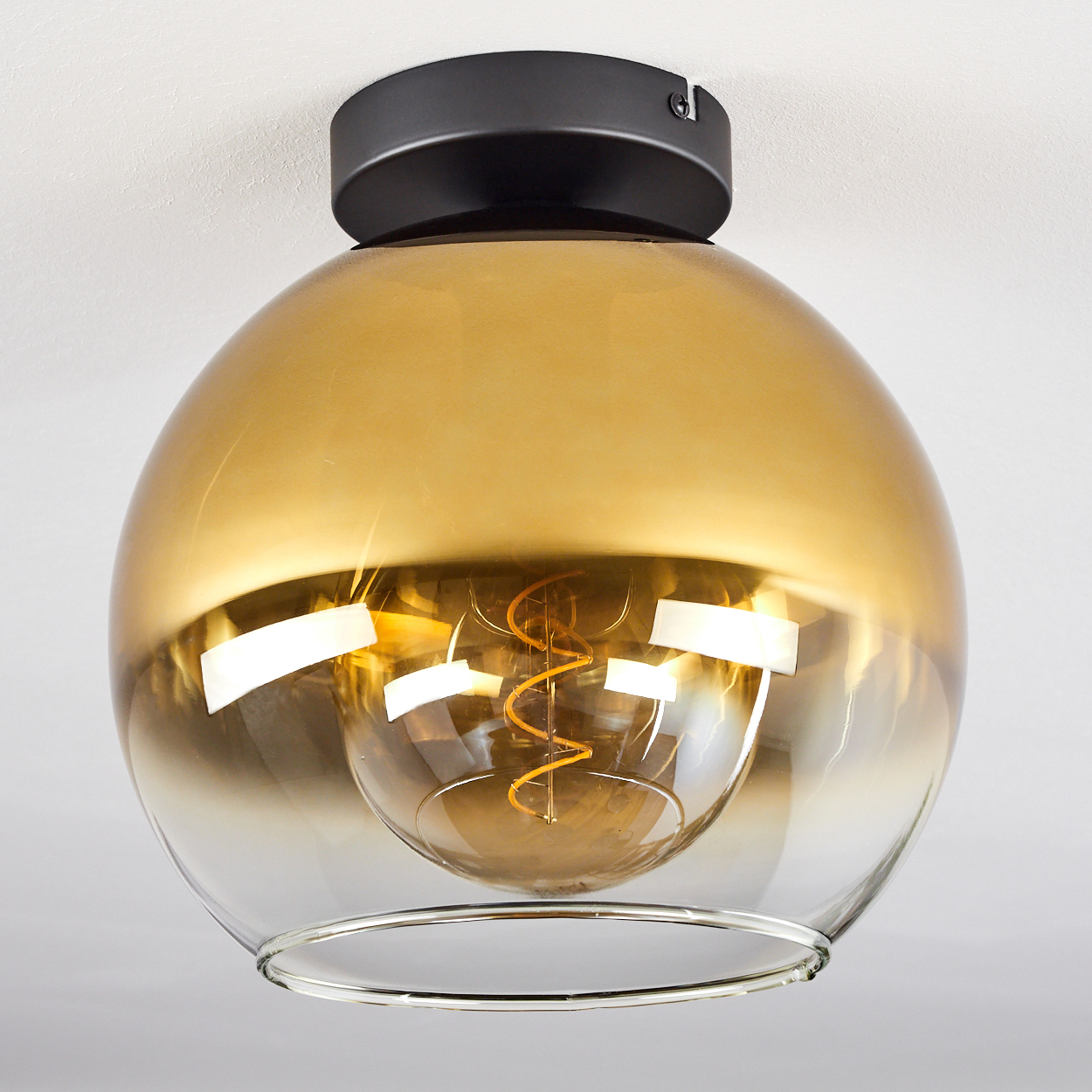 Eine moderne Deckenleuchte mit schwarzem Sockel und bernsteinfarbenem Glas.