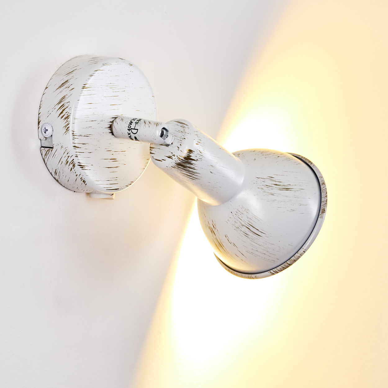 Eine weiße Wandleuchte mit verstellbarem Arm und Lampenschirm, die Licht abgibt.