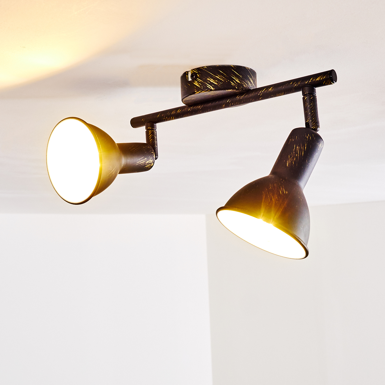 Dunkelbraune Deckenleuchte mit zwei verstellbaren Spots, goldene Akzente.
