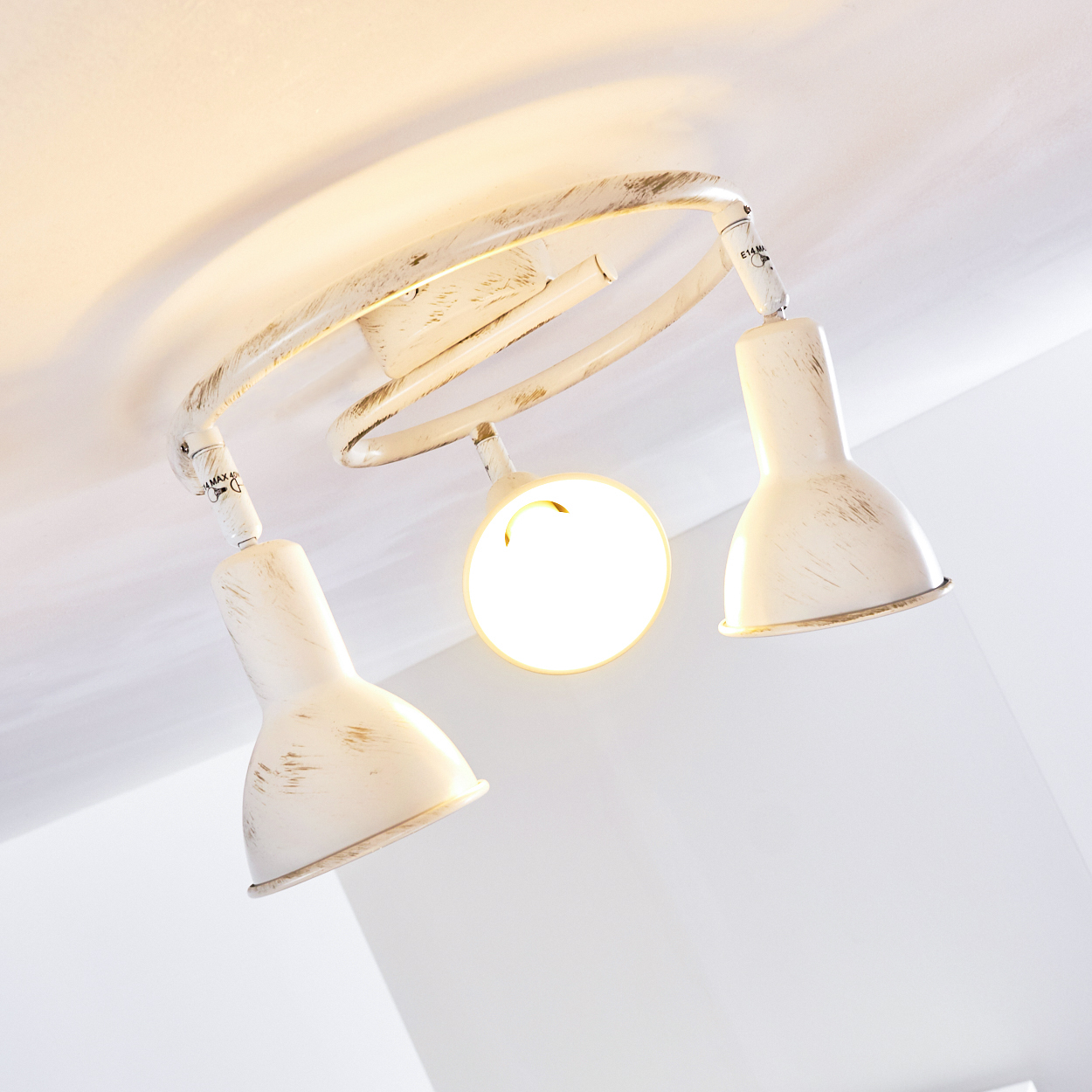 Eine weiße Deckenlampe mit drei verstellbaren Spots und Spiralarm.