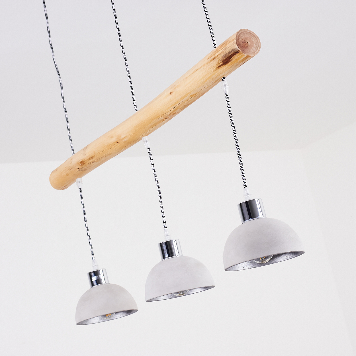 Dreiflammige Pendelleuchte mit Holzstamm und Betonlampenschirmen.