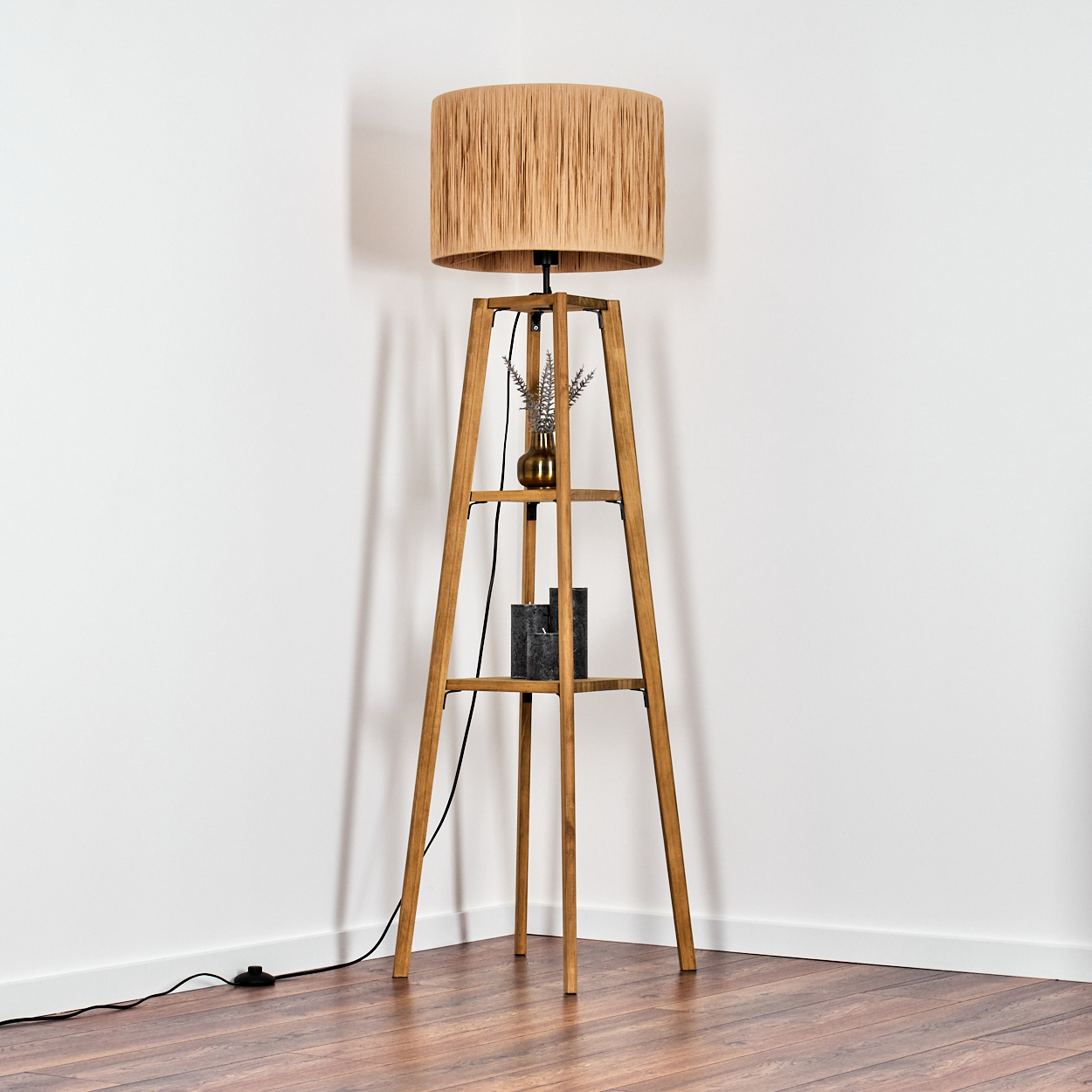Ein Stehlampe mit Holzgestell und beigem Lampenschirm, auf Holzfußboden.