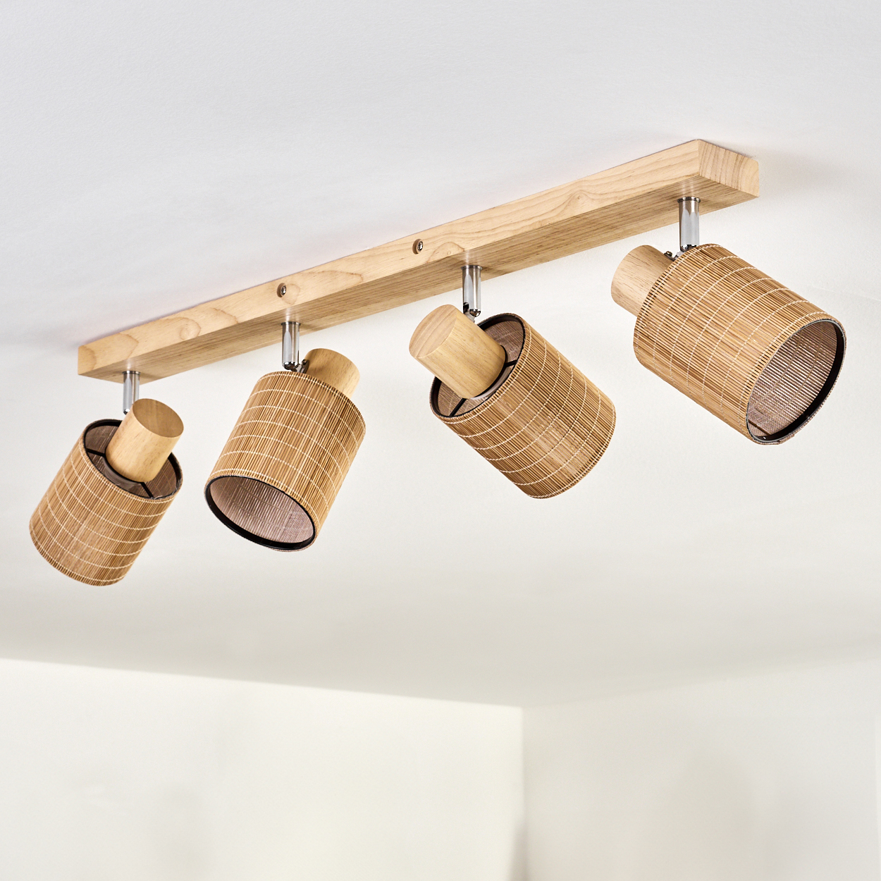 Vier braune Bambus-Spots an einem Holzfuß an der Decke.