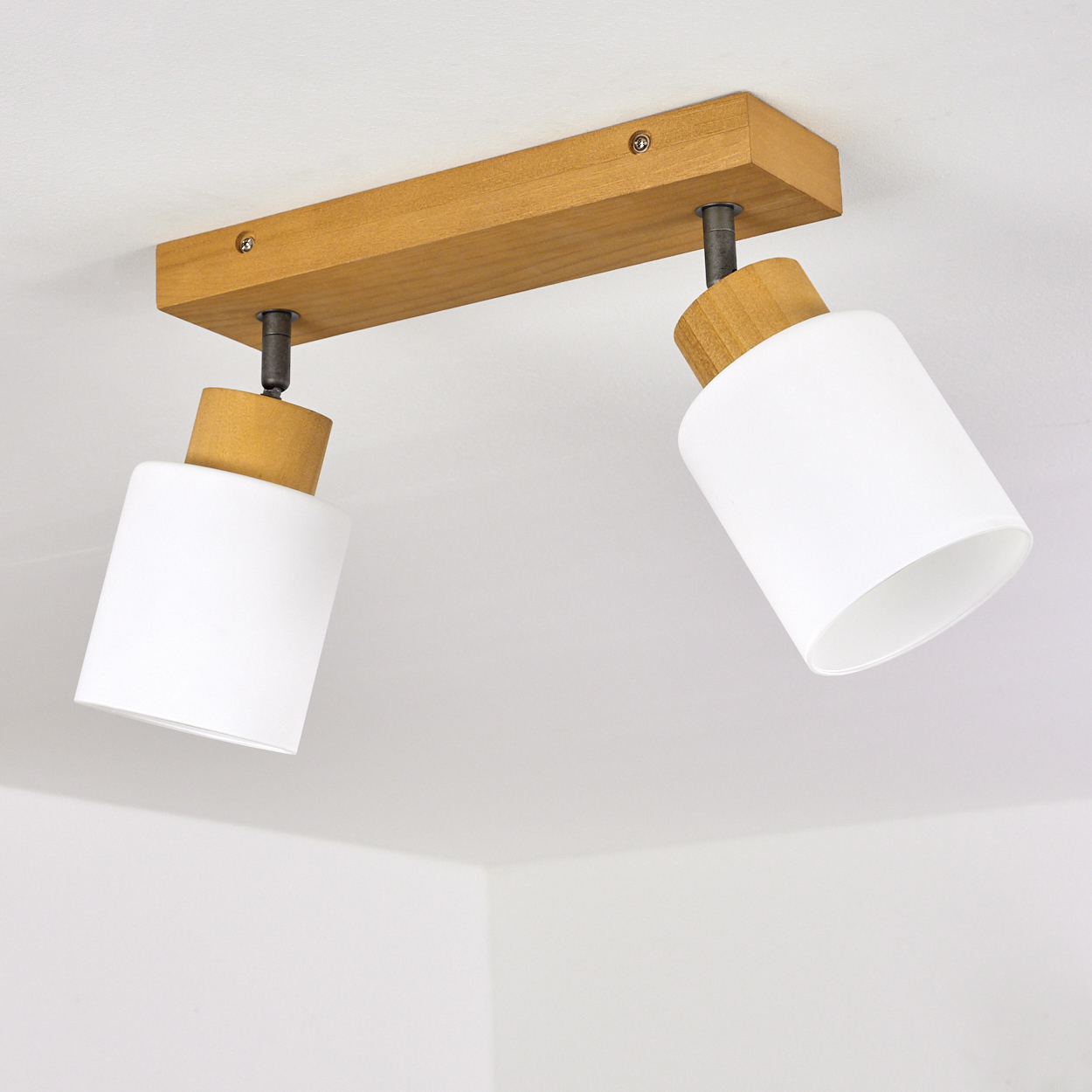 Eine Holzdecke mit zwei weißen Lampenschirmen und Holzakzenten.