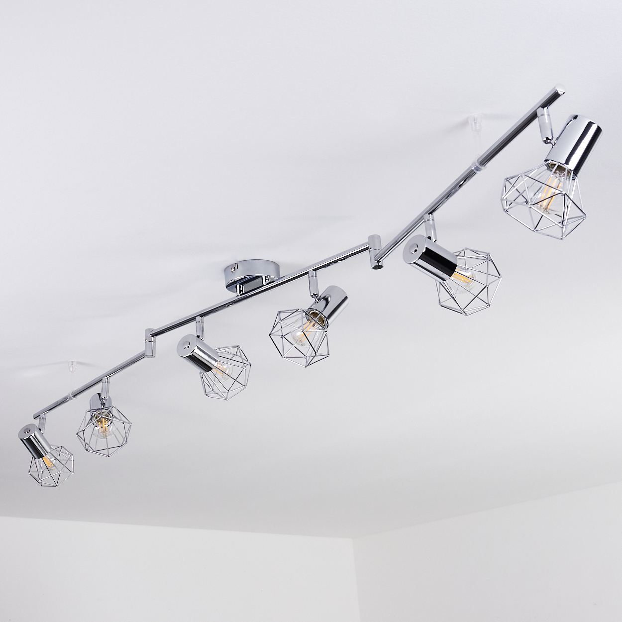 Eine silberne Deckenleuchte mit sechs Lampenköpfen im geometrischen Design.