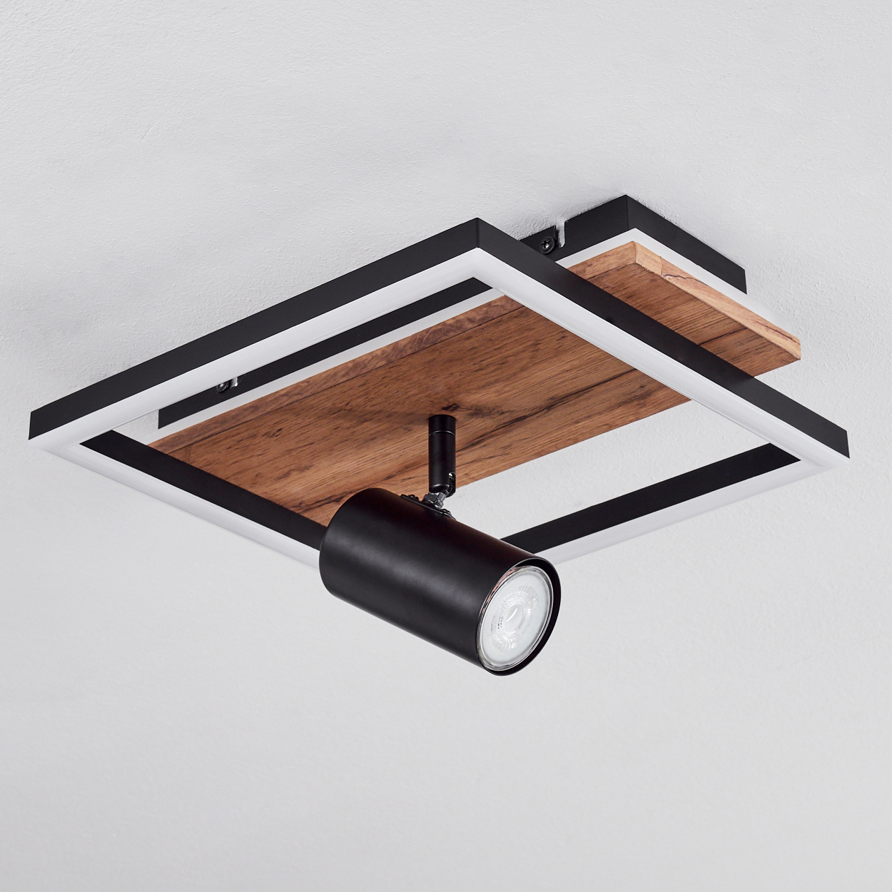 Deckenleuchte mit Holzplatte, schwarzem Rahmen und verstellbarem Spot.