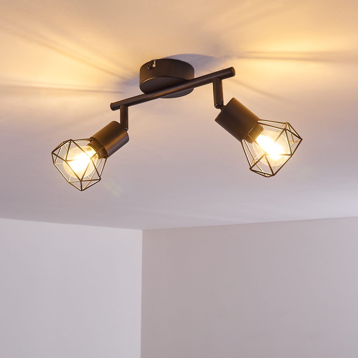 Schwarzer Deckenstrahler mit zwei Lampenschirmen im Gitterdesign.