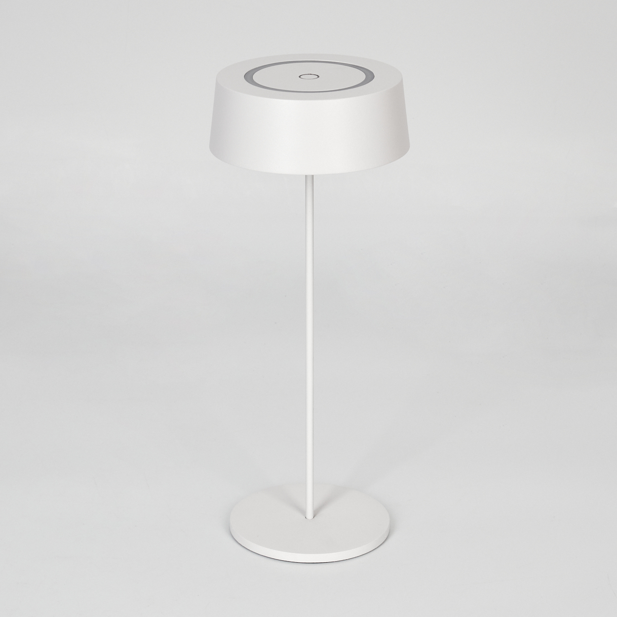Eine weiße Stehlampe mit rundem Sockel und einem zylindrischen Lampenschirm mit grauen Ringen.