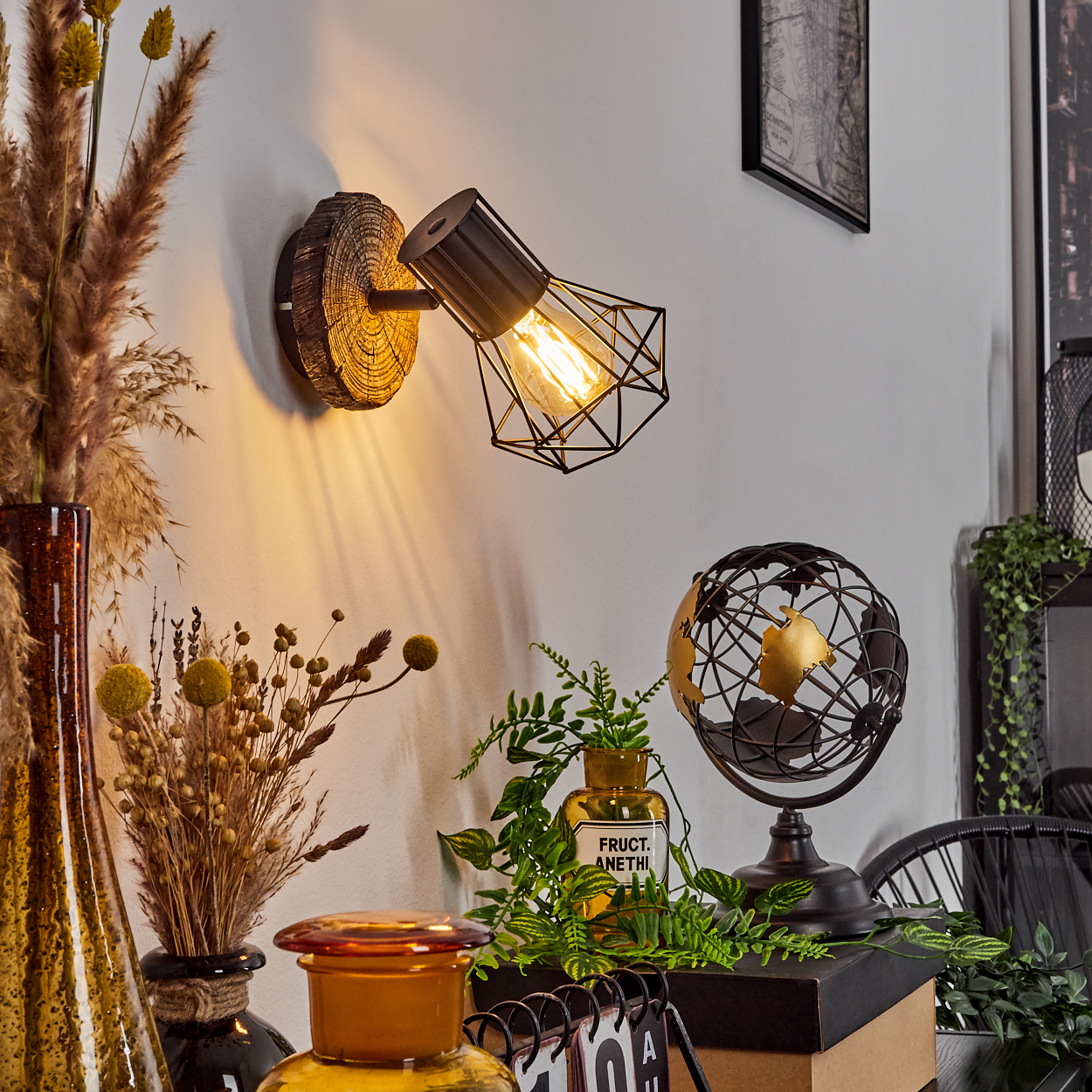 Ein Wandspot mit Holzsockel beleuchtet einen Schreibtisch mit Dekoartikeln.