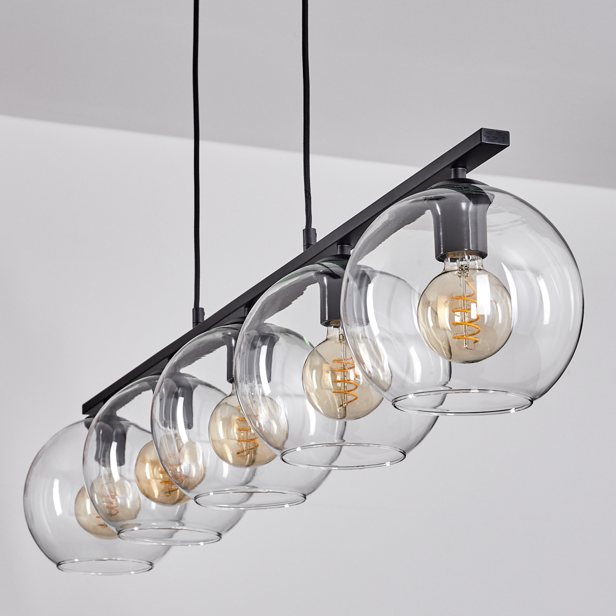 Moderne Hängelampe mit fünf klaren Glaskugeln und Edison-Glühbirnen.
