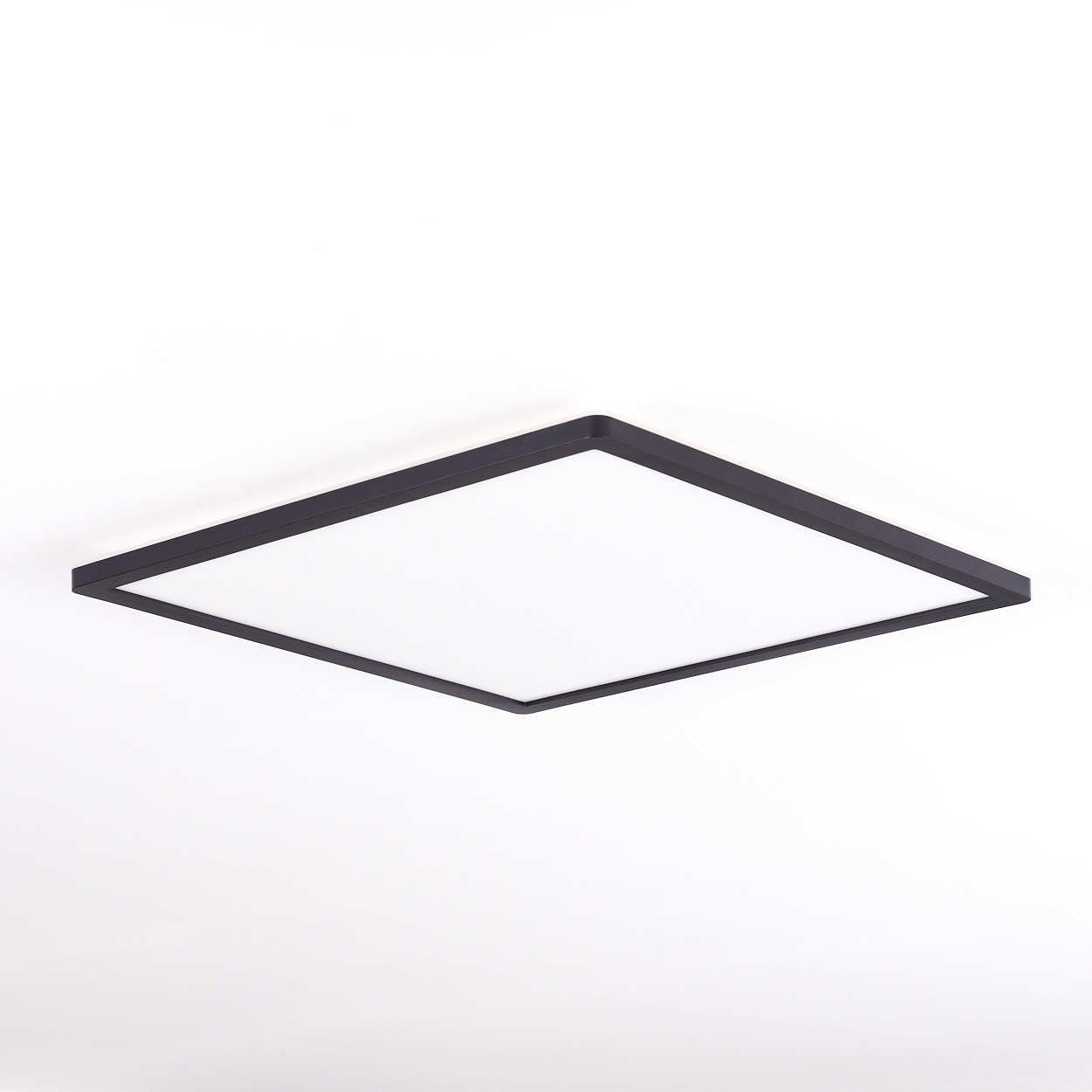Ein quadratisches, schwarzes Deckenlicht mit weißer Mitte auf weißem Hintergrund.