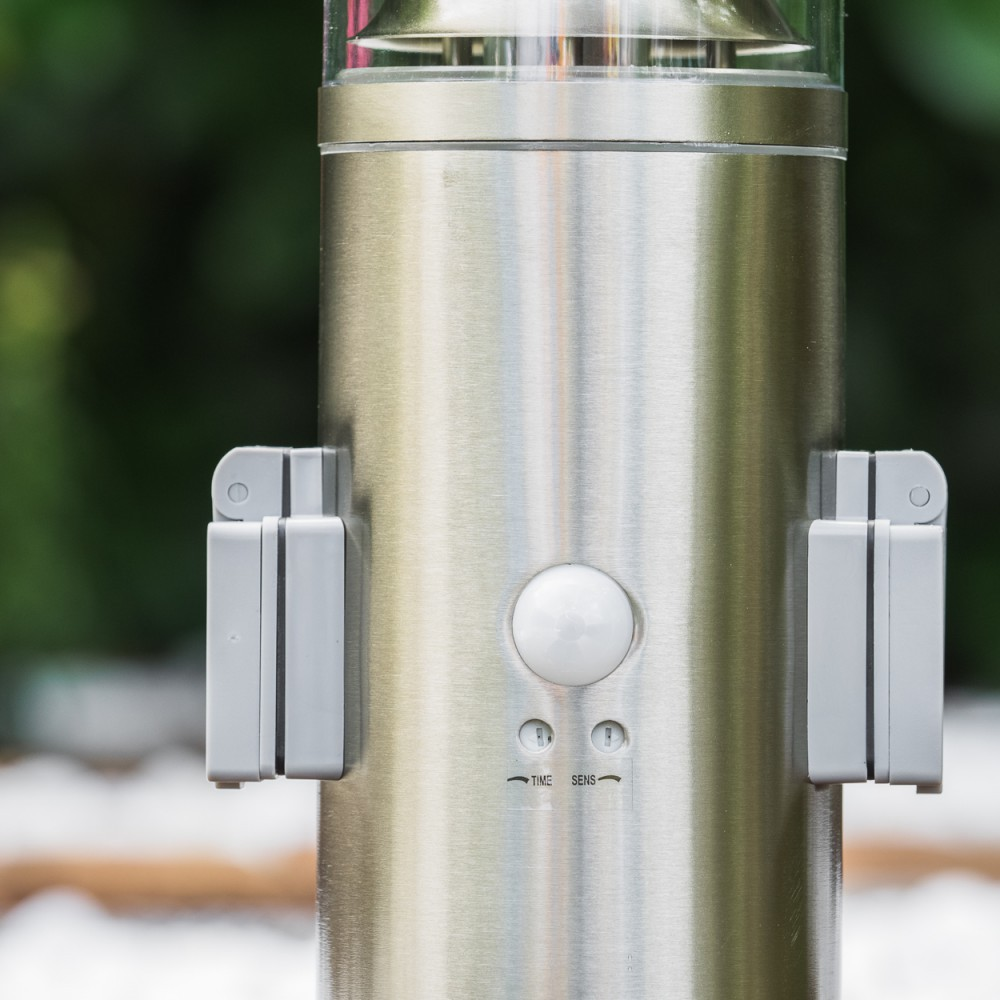 Nahaufnahme einer gebürsteten Metalllampe mit Bewegungssensor und zwei grauen Halterungen.