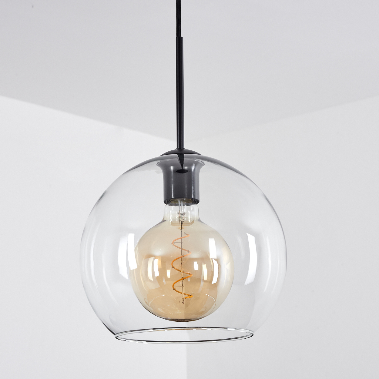 Eine transparente Glaskugel-Pendelleuchte mit einer Edison-Glühbirne.