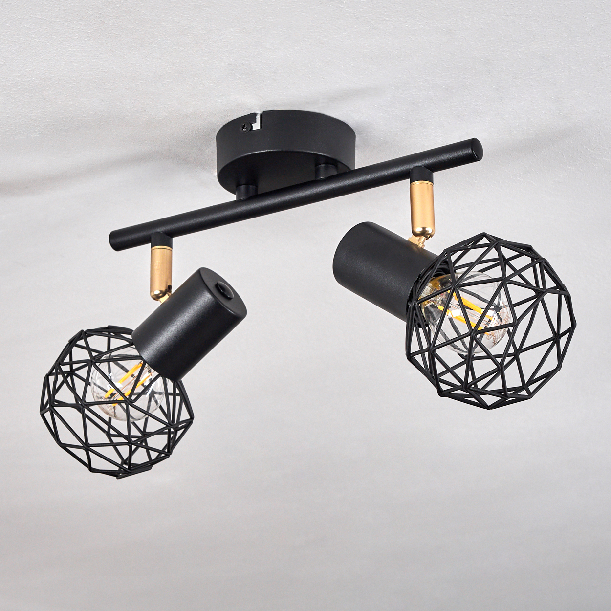 Schwarzer Deckenstrahler mit zwei Lampen und geometrischen Gitterschirmen.