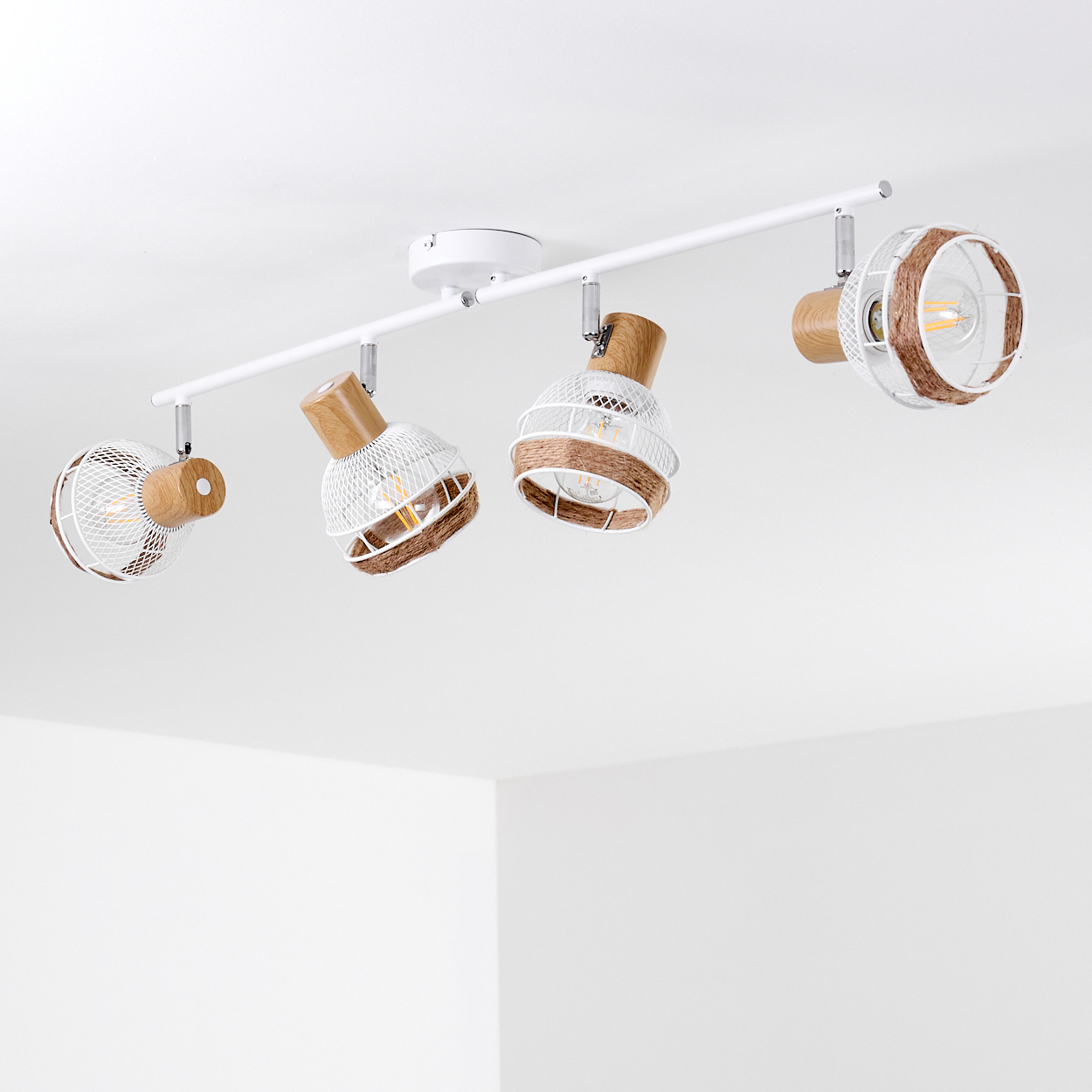 Weiße Deckenleuchte mit vier Lampenschirmen aus Drahtgeflecht und Holzdetails.