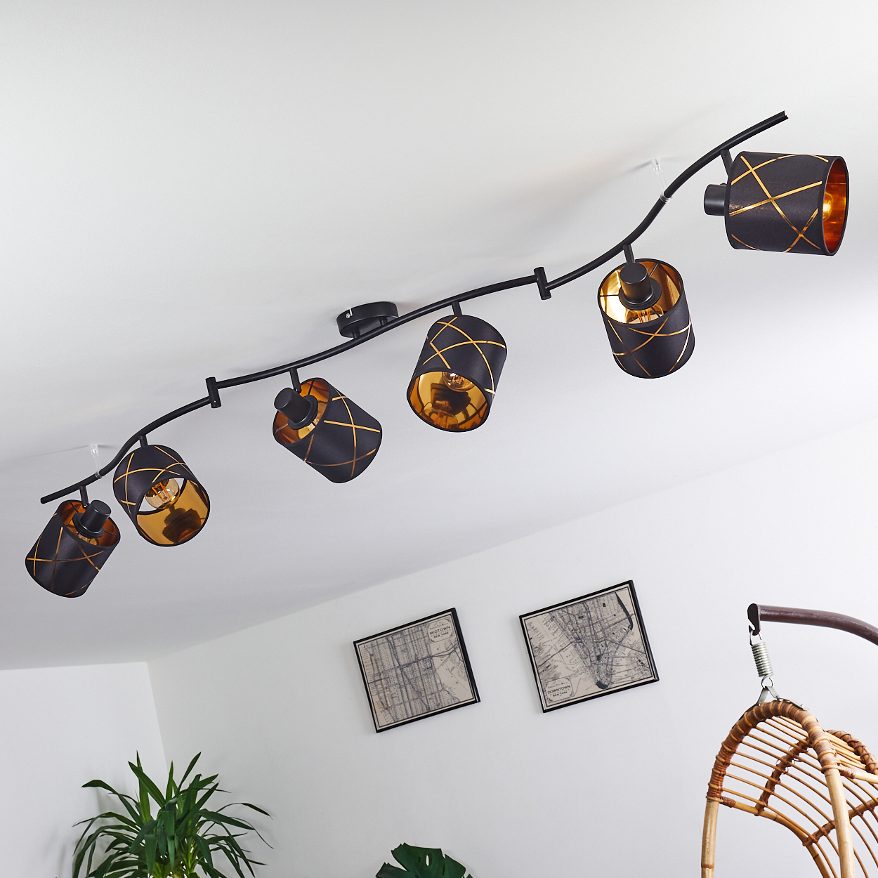 Eine schwarze Schienenleuchte mit goldenen Akzenten an einer weißen Decke.