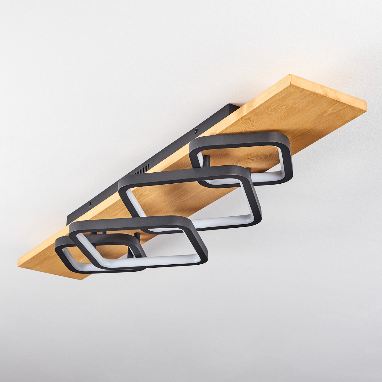 Moderne Deckenleuchte mit Holzplatte und vier quadratischen Leuchten.
