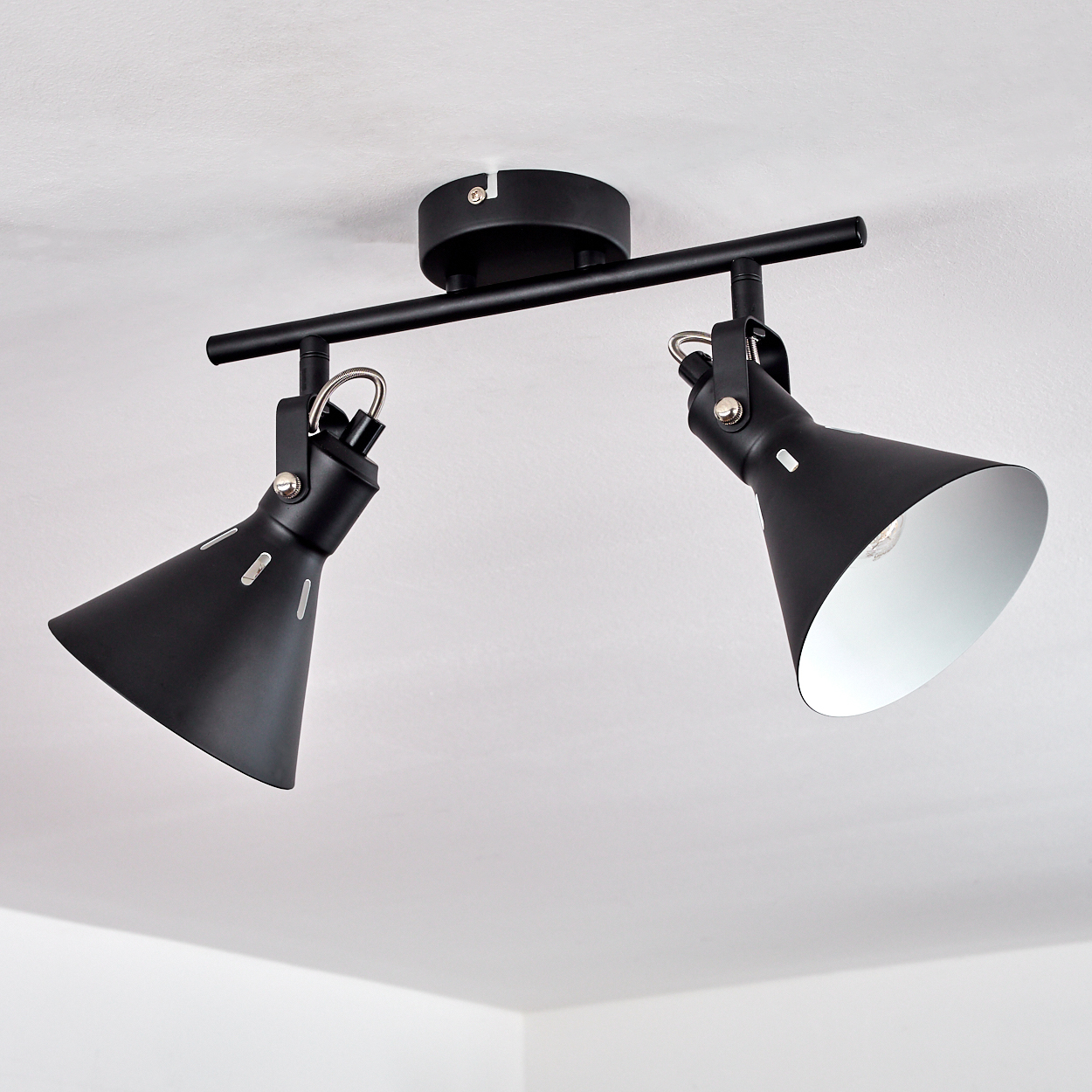 Schwarze Deckenleuchte mit zwei verstellbaren kegelförmigen Spots und silbernen Innenseiten.