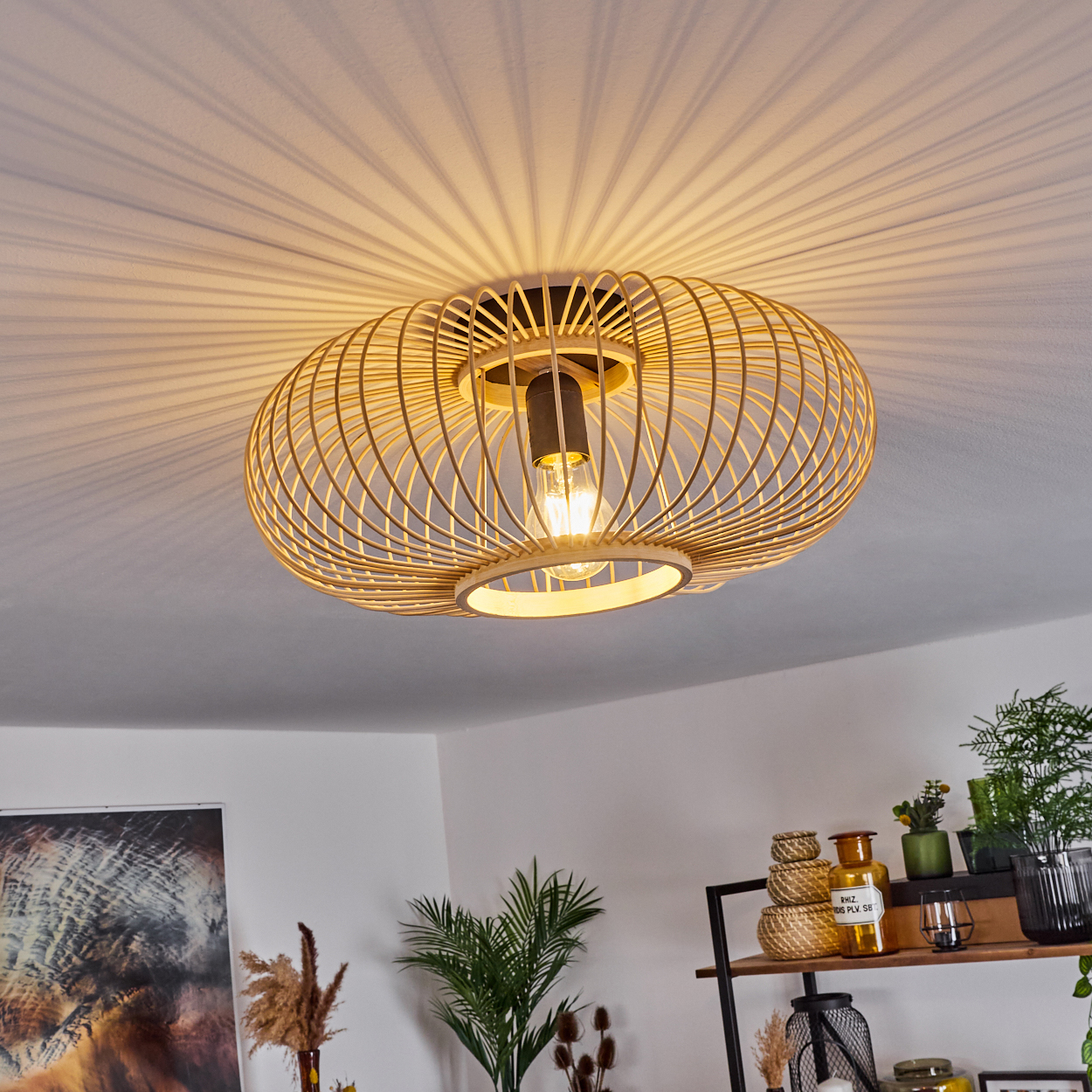 Eine runde, geflochtene Holzdekor-Lampe mit sichtbarem Leuchtmittel wirft Schatten.