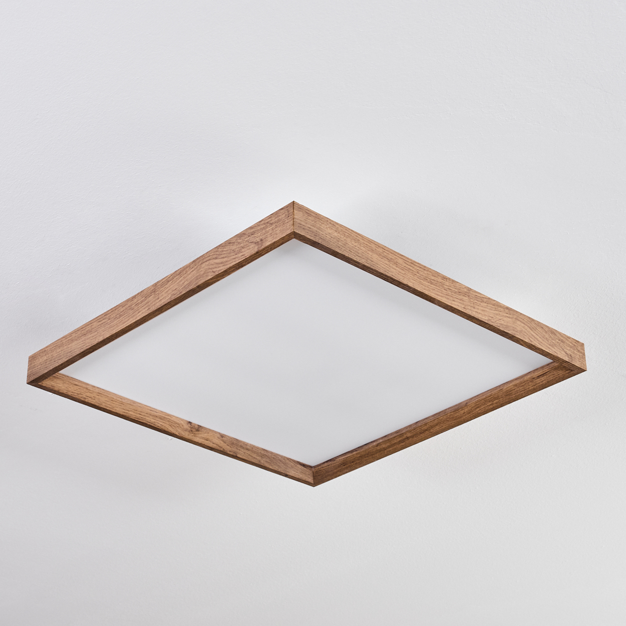 Eine quadratische Deckenleuchte mit Holzrahmen auf weißem Hintergrund.