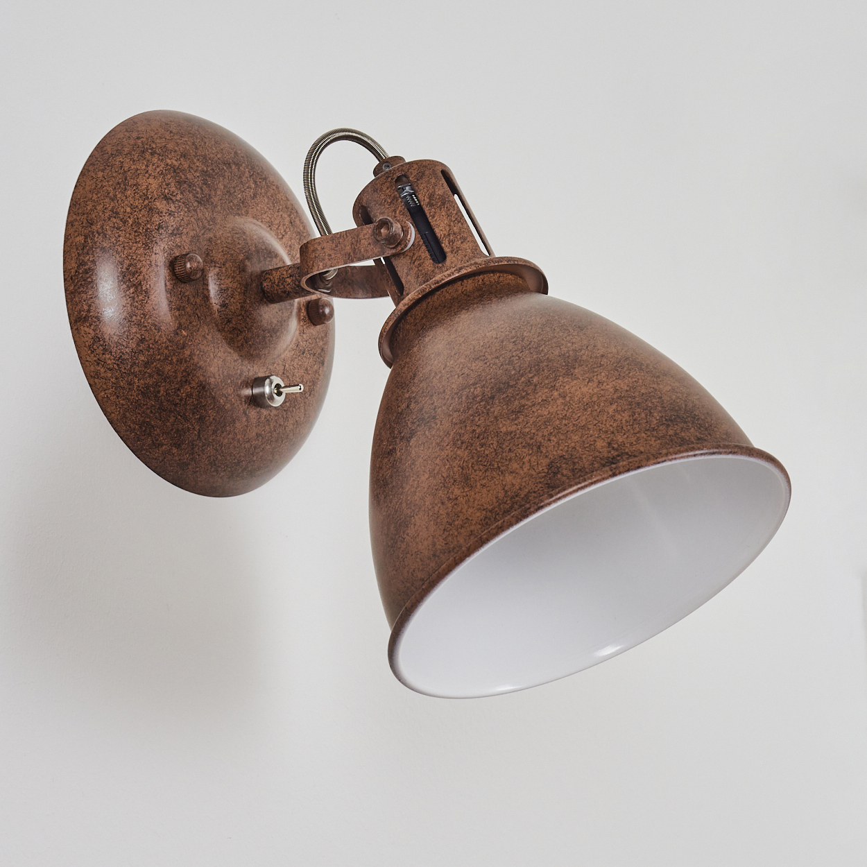 Eine rustikale braune Wandlampe mit texturierter Oberfläche und weißem Inneren.