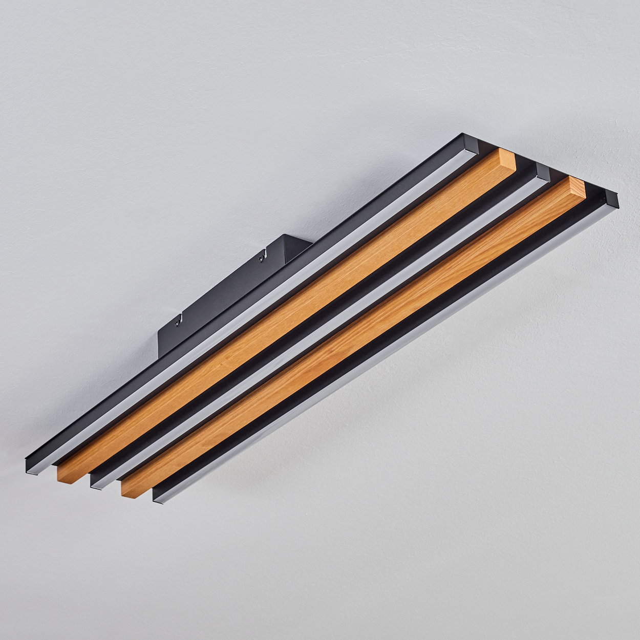 Moderne Deckenleuchte mit Holzelementen und schwarzen Streifen.