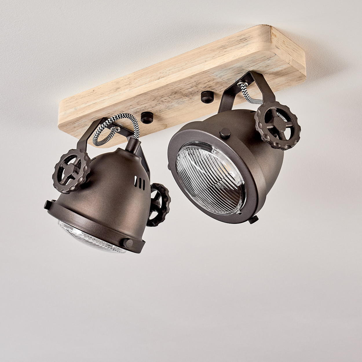 Zwei braune Scheinwerfer mit Holzsockel und Zahnraddetails an der Decke.