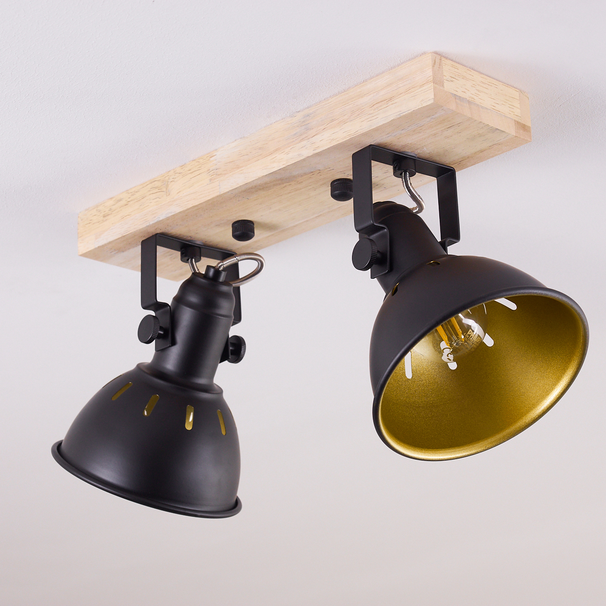 Zwei schwarze Lampenschirme mit Holzbasis an der Decke.