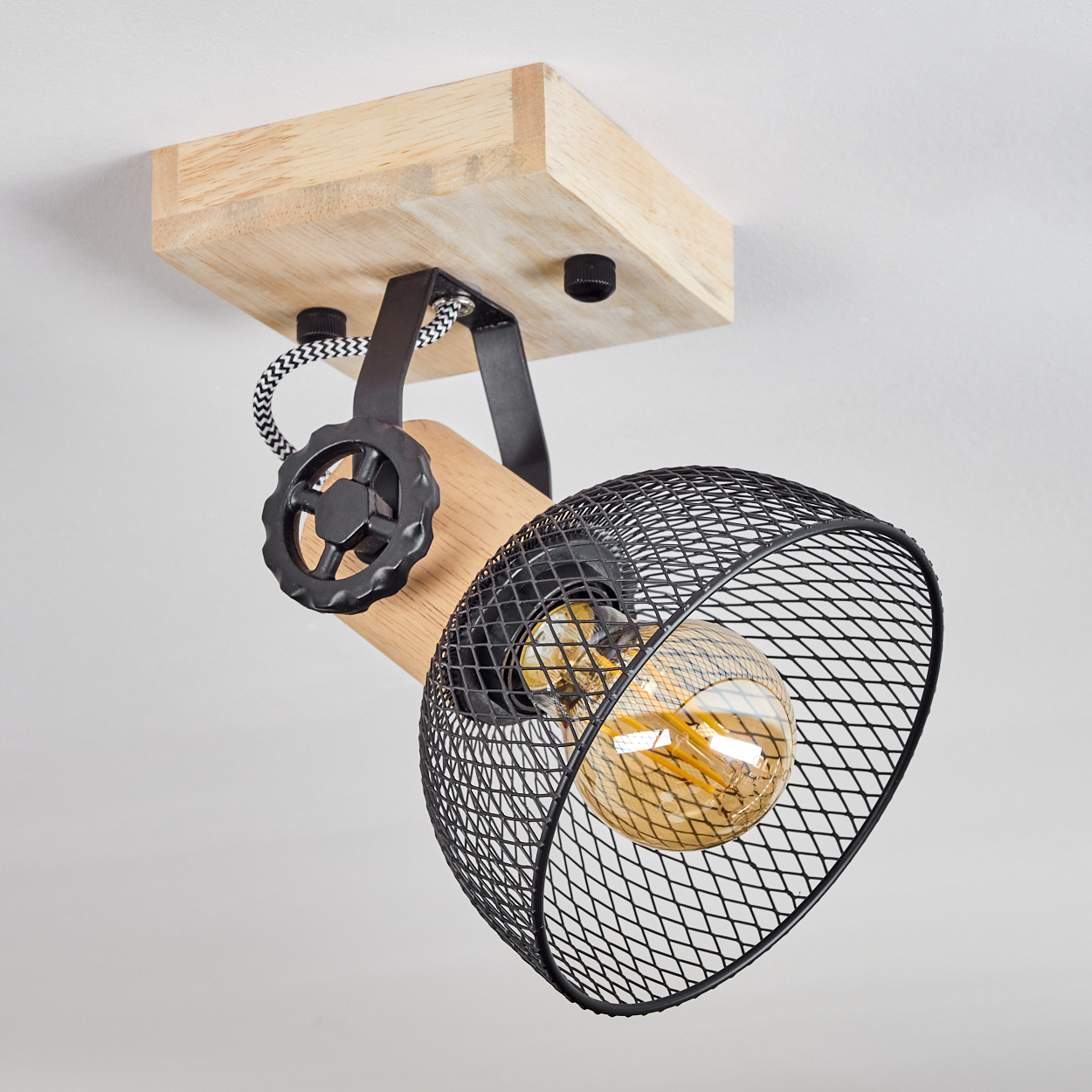 Eine Deckenleuchte aus Holz mit schwarzem Metallgitter und sichtbarer Edison-Glühbirne.