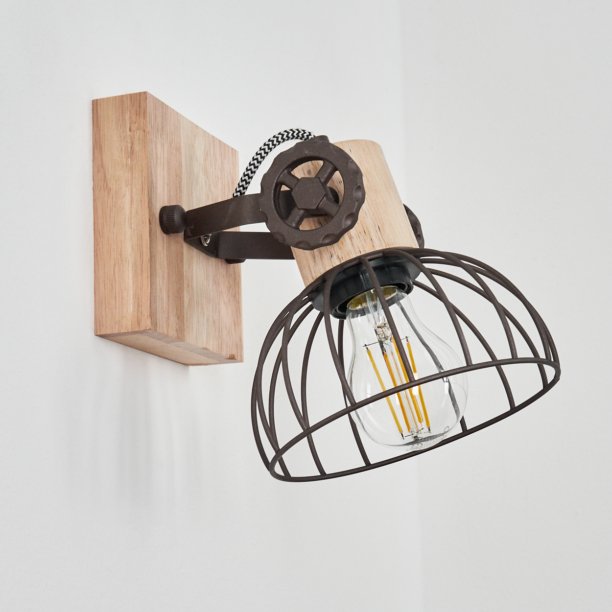 Eine Wandleuchte aus Holz und Metall mit einem Drahtkorb und sichtbarer Glühbirne.