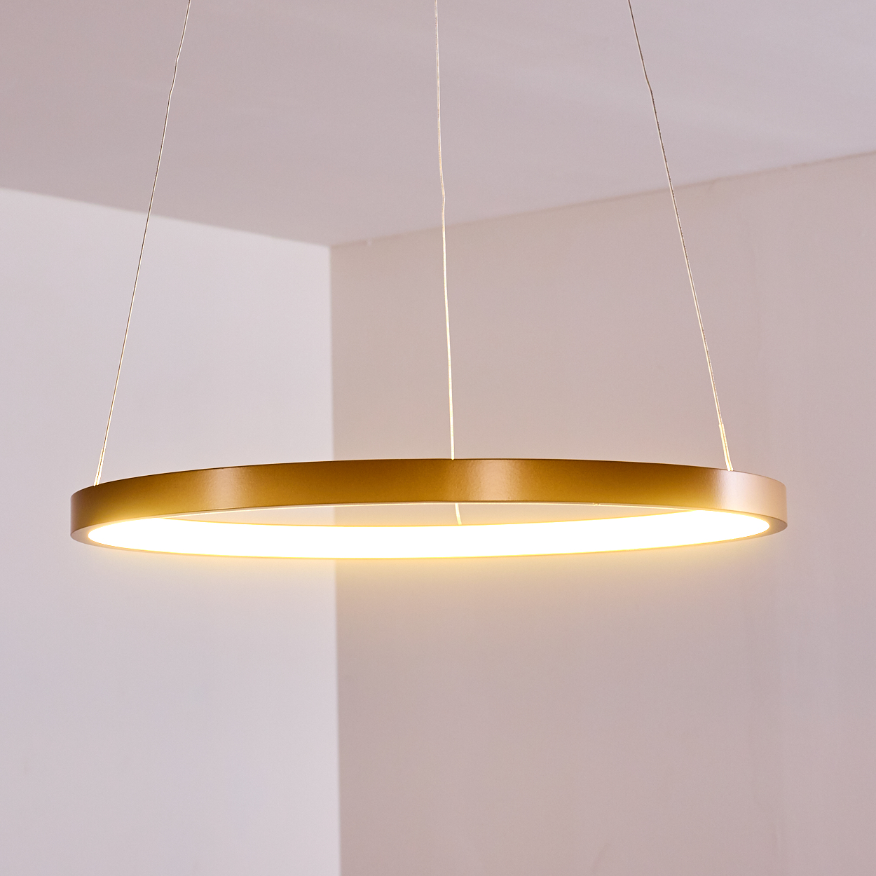 Goldener Ring-Deckenleuchter mit warmweißer Beleuchtung, hängt an dünnen Kabeln.