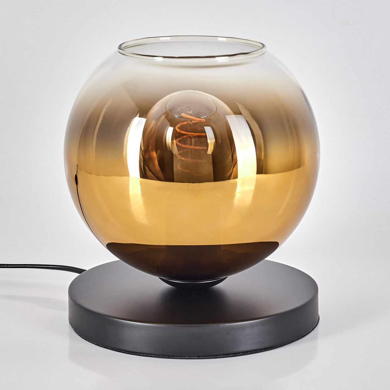 Eine kugelförmige Lampe mit goldfarbenem Schirm und sichtbarer Glühbirne.