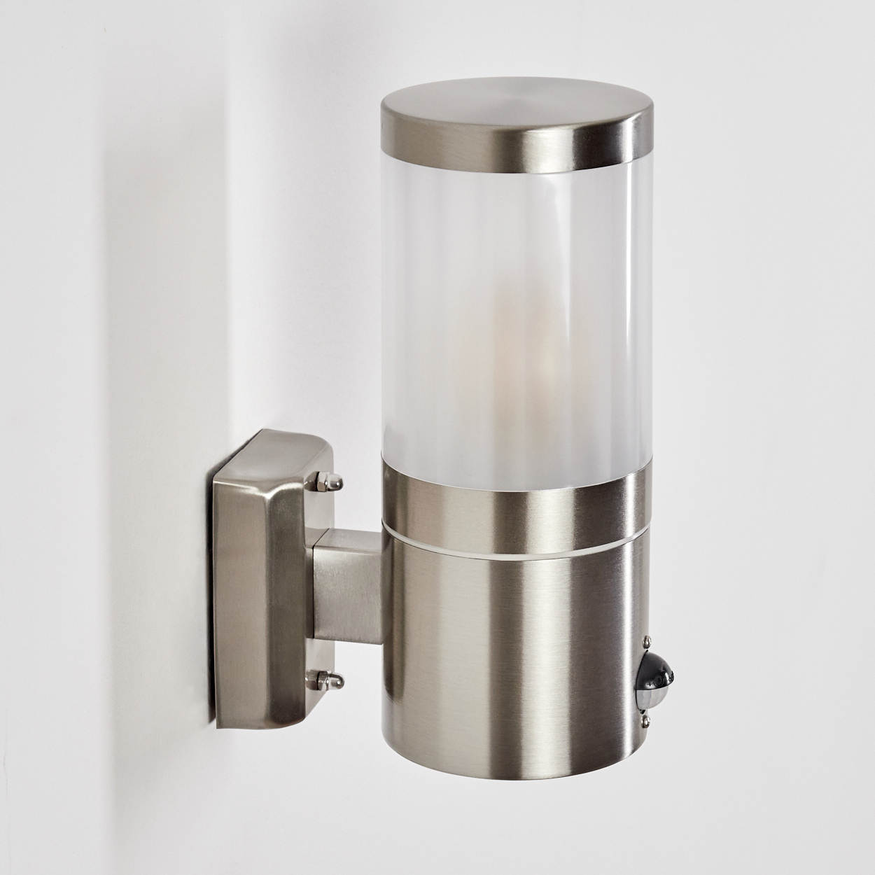 Eine silberne Wandleuchte mit mattem Glaszylinder und Bewegungsmelder.