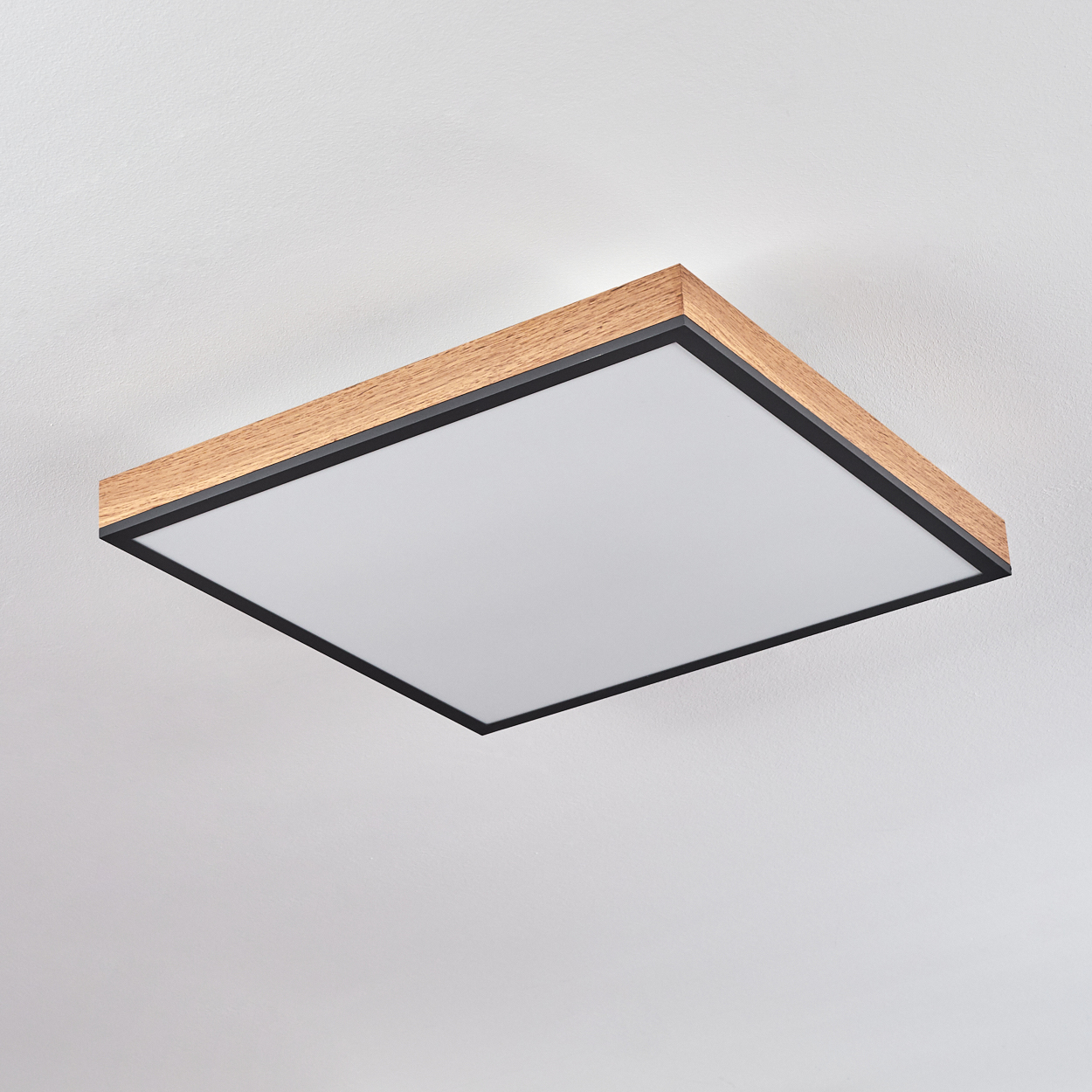 Eine quadratische Deckenleuchte mit Holzrahmen und weißem Diffusor.