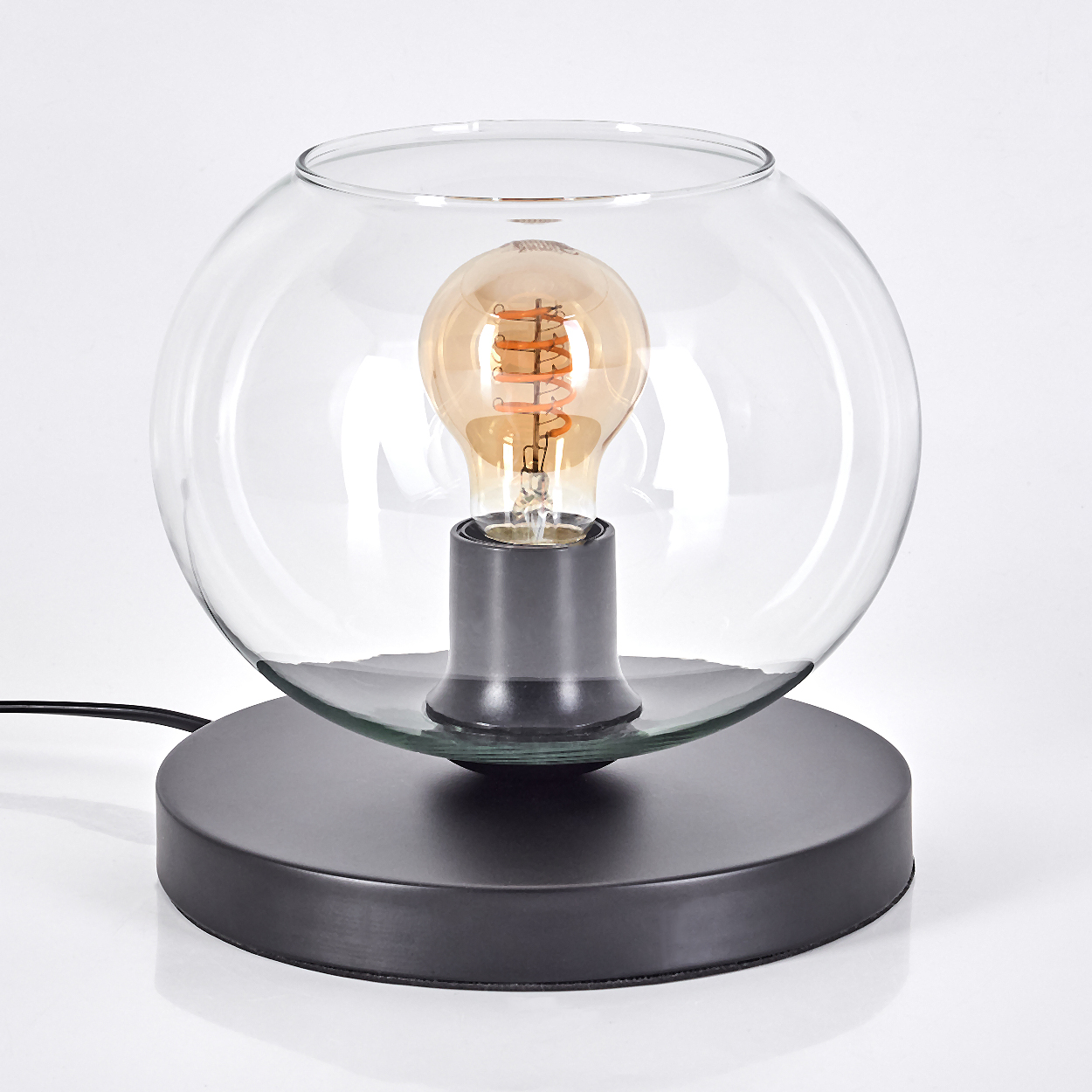 Eine runde Glaskugel umschließt eine Edison-Glühbirne auf einem dunklen Sockel.