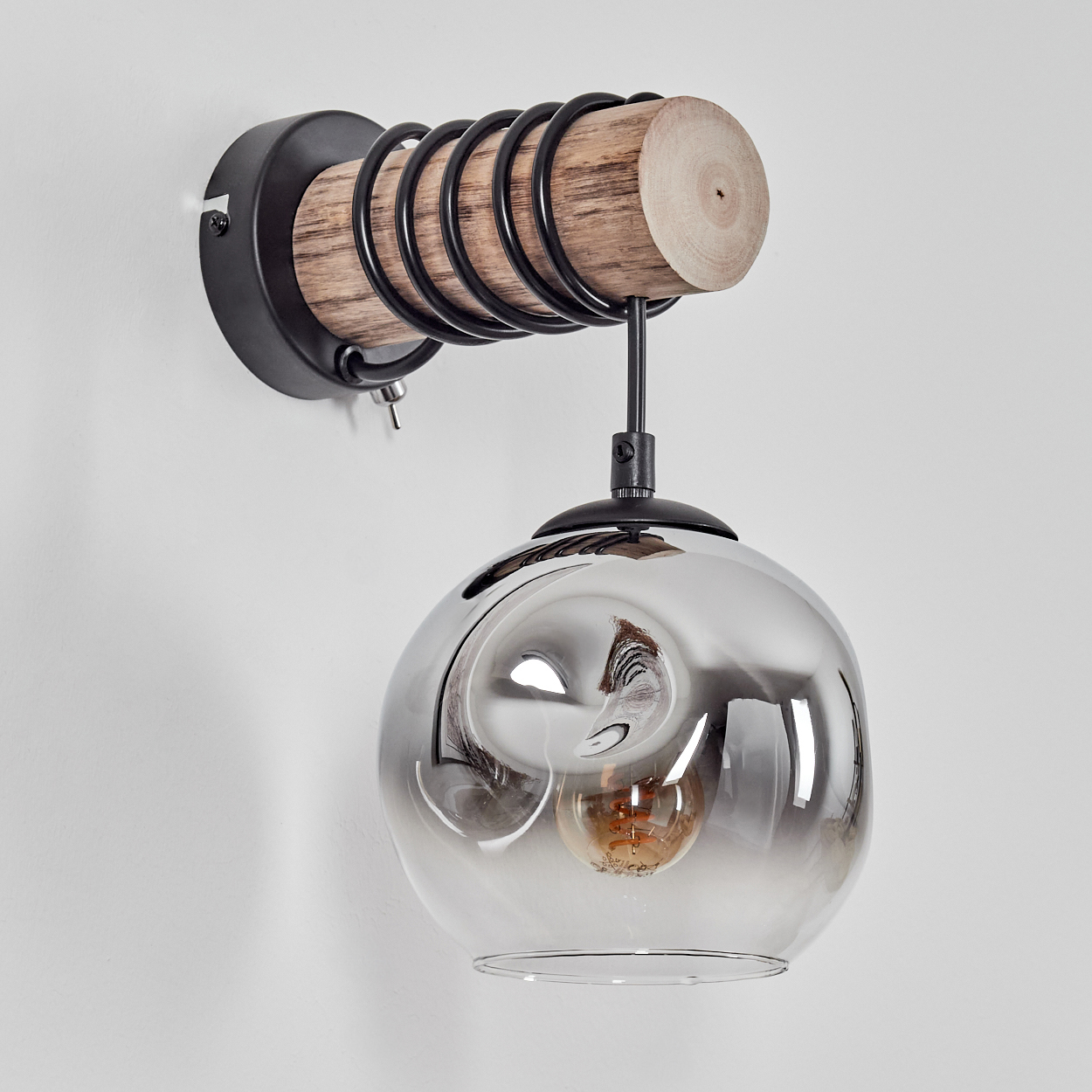 Eine moderne Wandleuchte mit Holzbalken, schwarzem Metall und einem rauchigen Glasschirm.