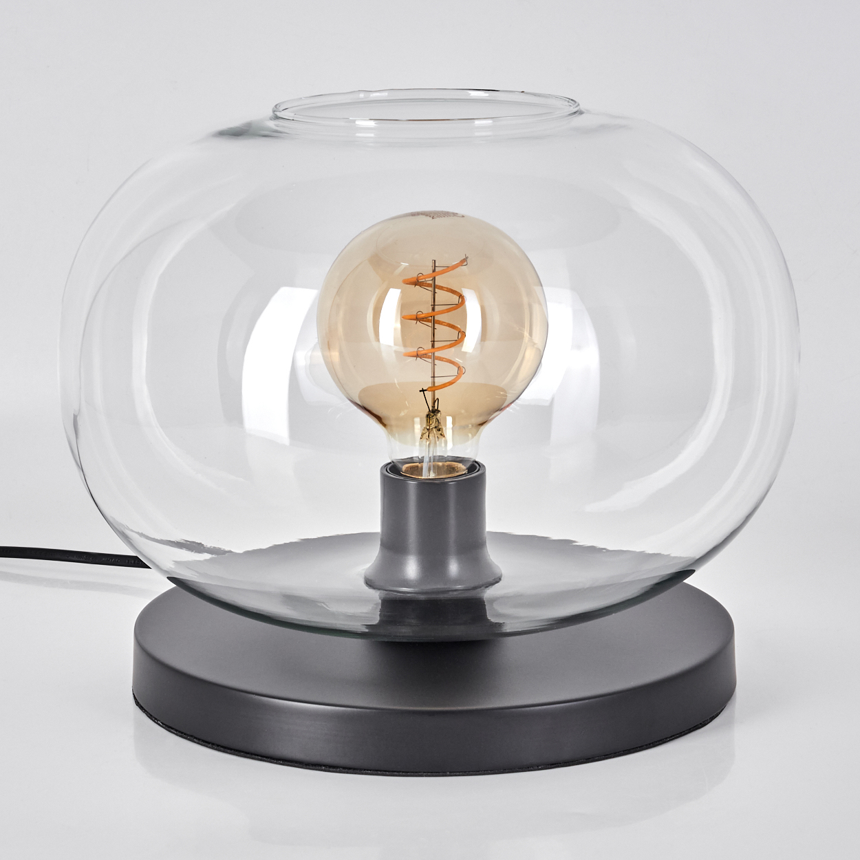 Eine moderne Glaskugel-Lampe mit sichtbarer Edison-Birne und dunklem Sockel.