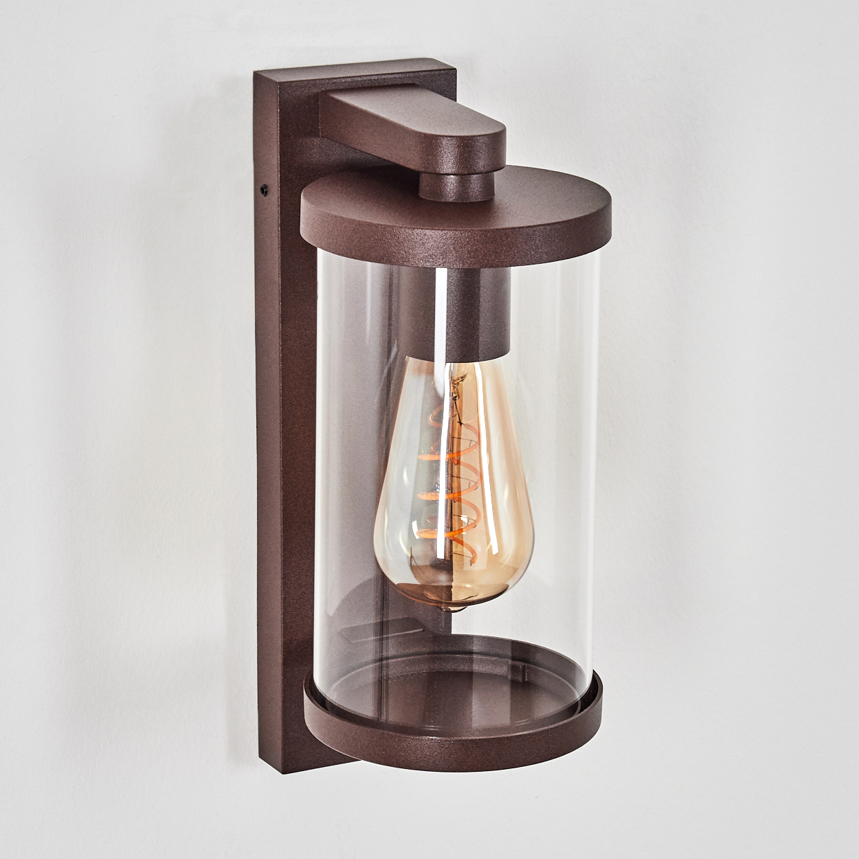 Eine braune Wandleuchte mit Glaszylinder und sichtbarer Glühbirne.
