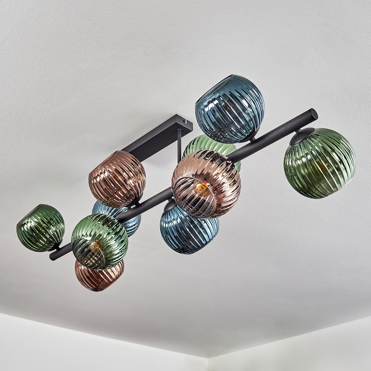 Deckenleuchte mit neun kugelförmigen Lampenschirmen in Grün, Blau und Kupfer.